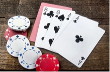 poker hand showing two aces and two eights with poker chips scattered around