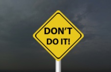 An image of a yellow road sign with the words ‘don’t do it!’ on a dark, cloudy background 