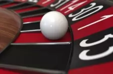 A closeup photo of a roulette wheel with the white ball in the red ‘1’ slot