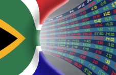 An image of the South African flag against a large stock market digital display